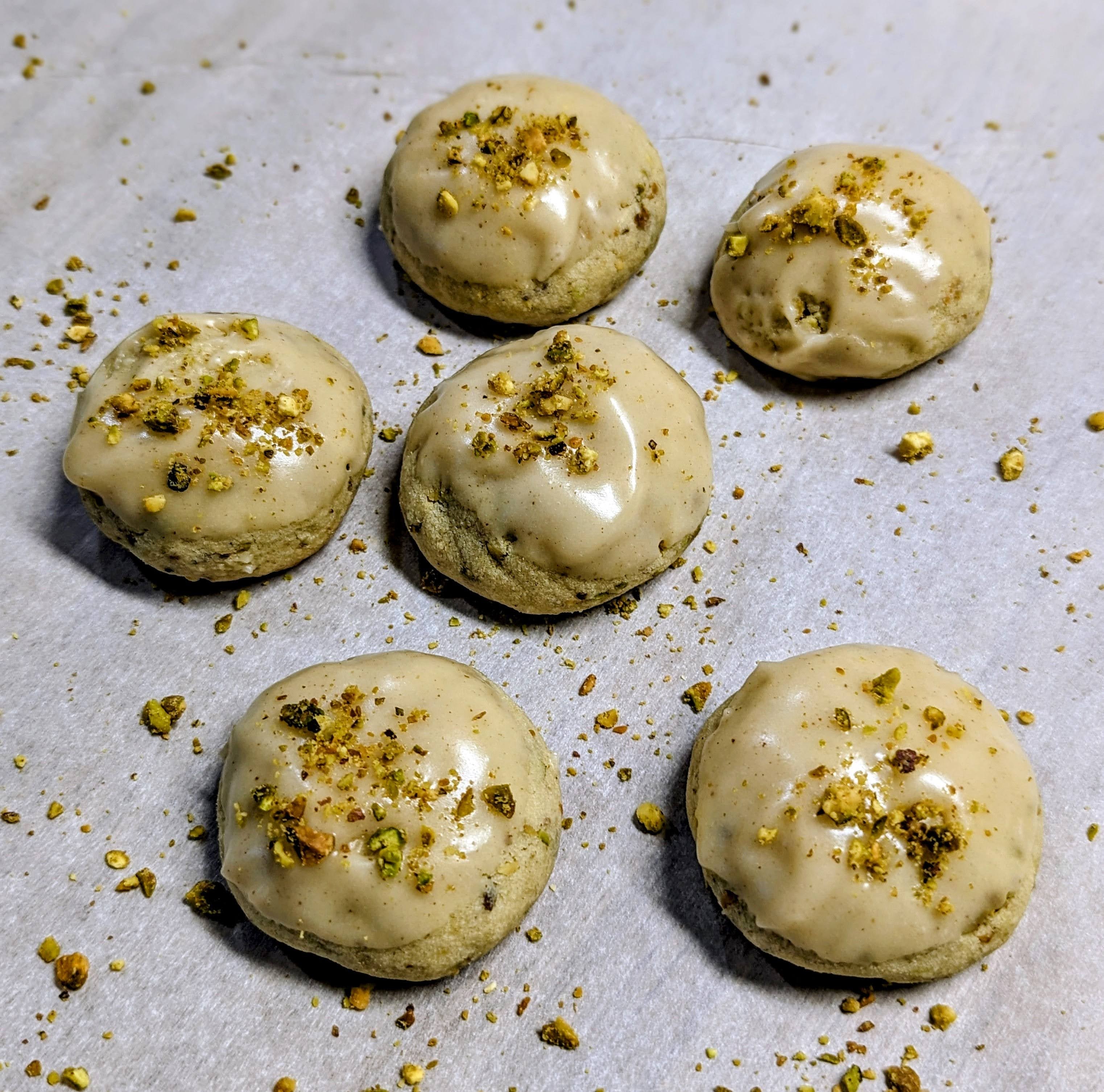 Pistachio macarons with crushed nuts topping on parchment