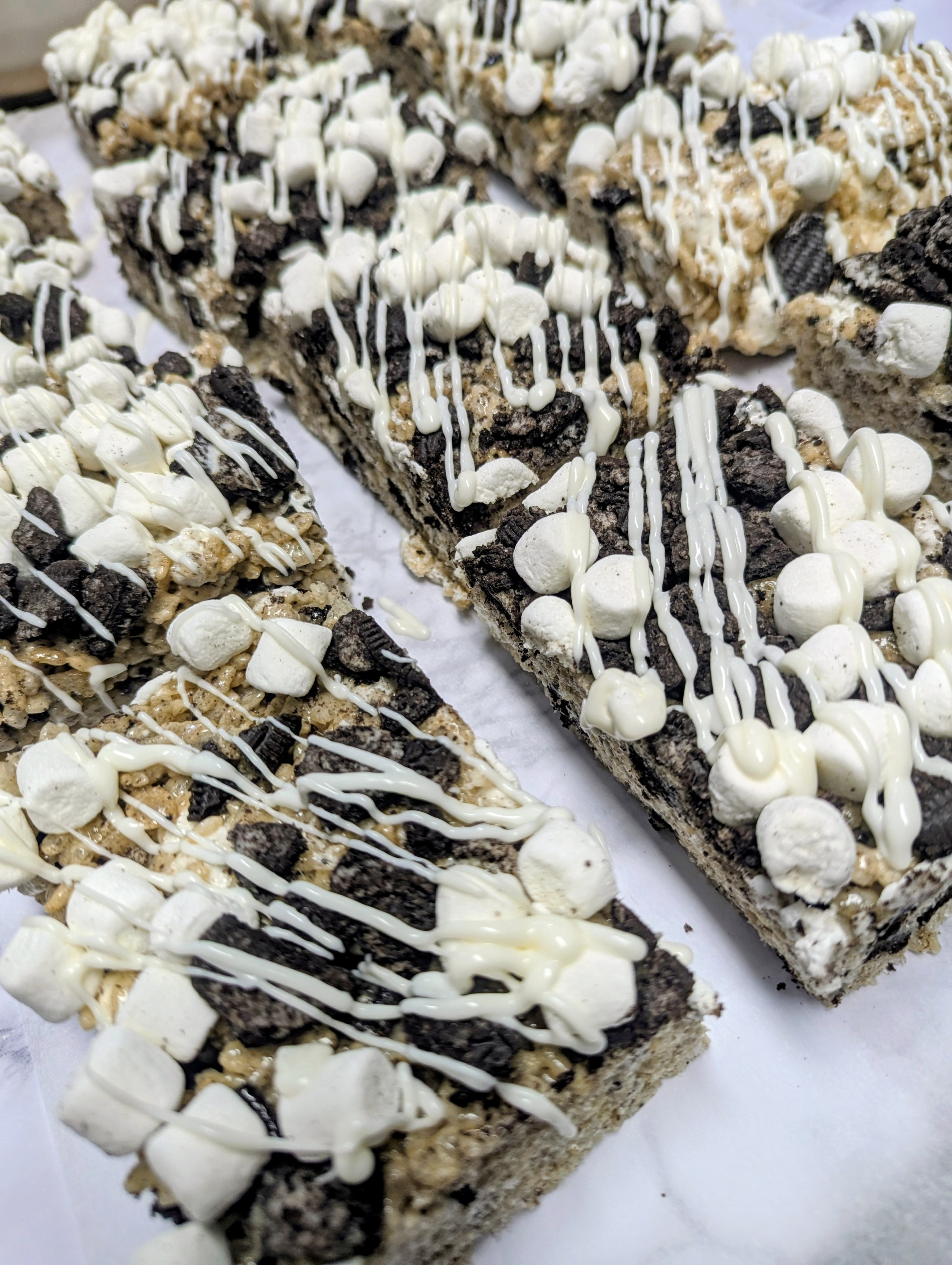 Cookies and cream crispy treat bars sliced on parchment