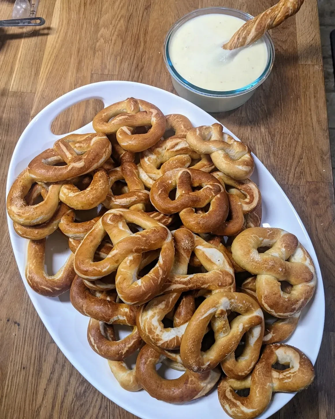 Soft pretzels piled on a platter with a creamy dipping sauce